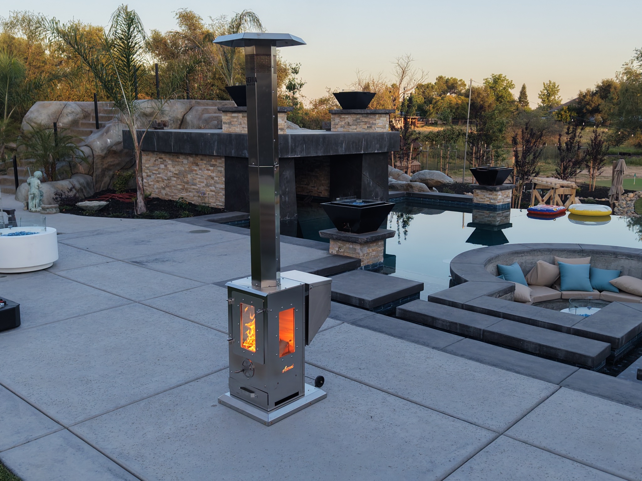 Sierra Stoves Ascent heater glowing orange on luxury pool patio at dusk